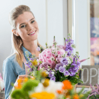 blonde event planning expert arranging purple and pink flowers 